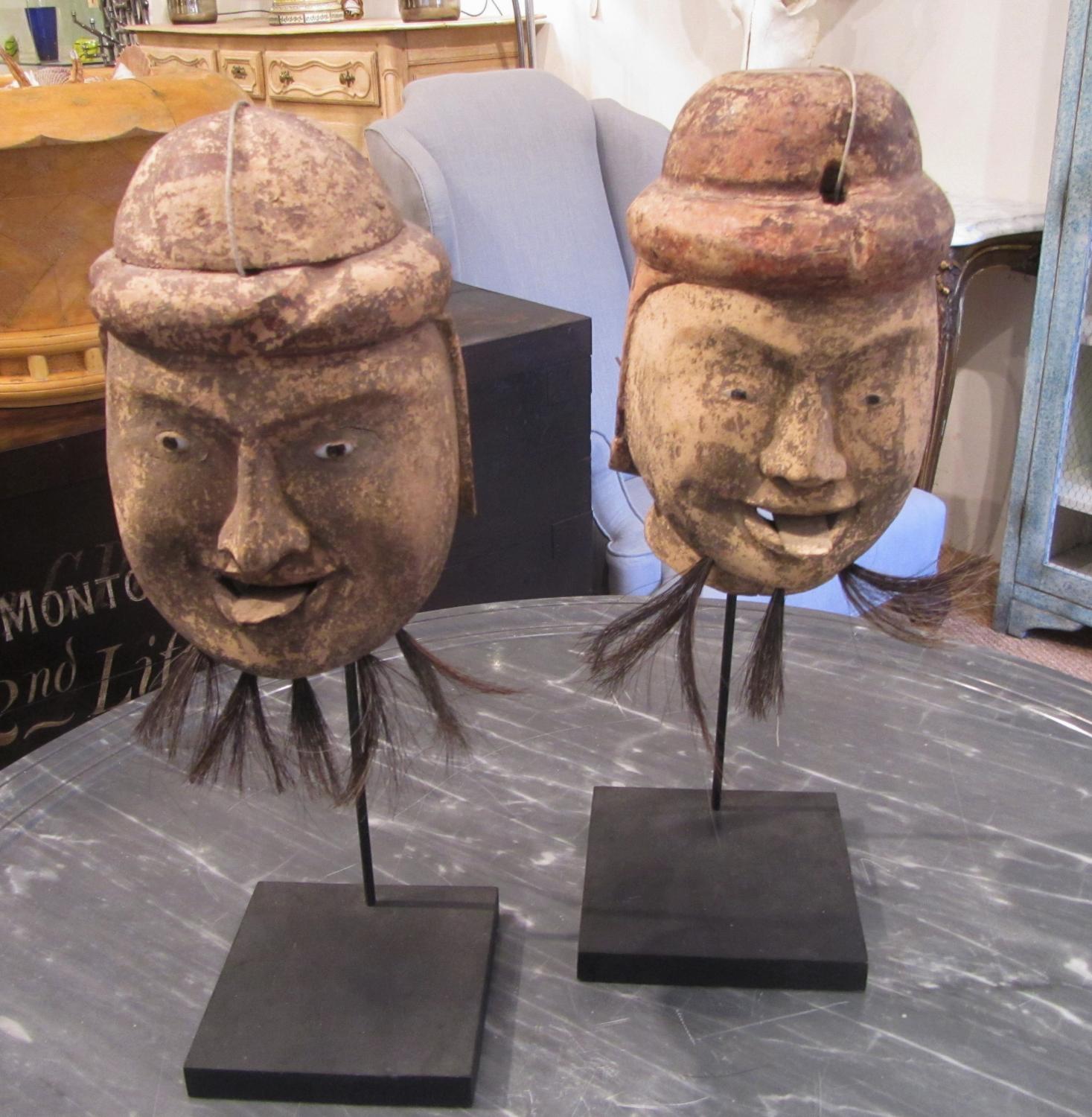 Two carved wood puppet heads