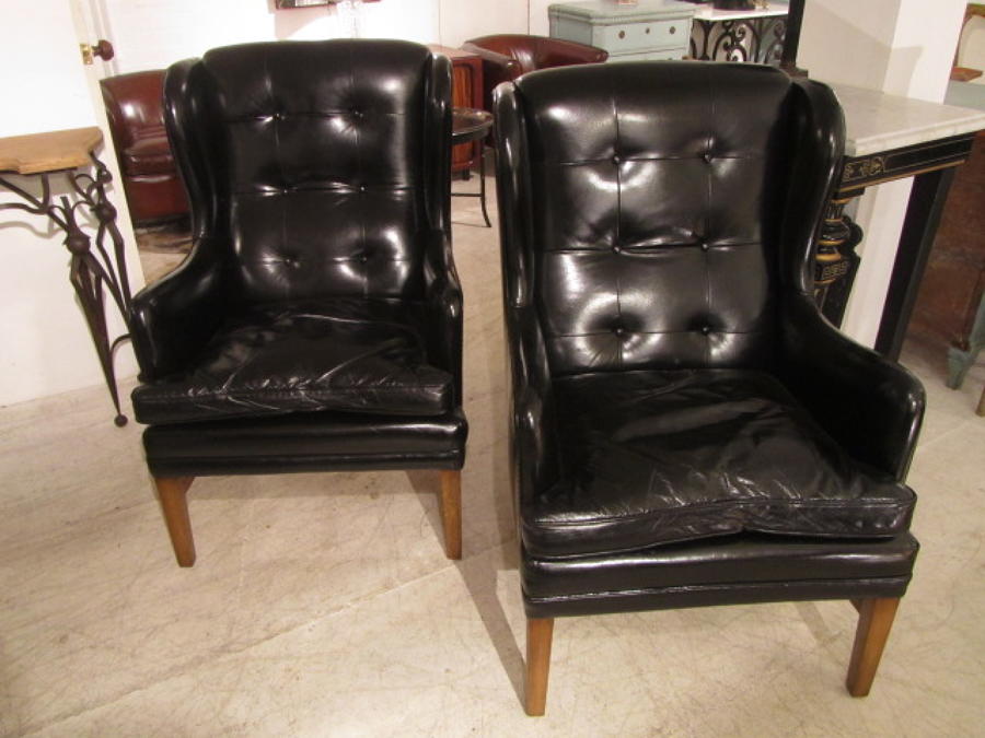 A pair of wing leather armchairs