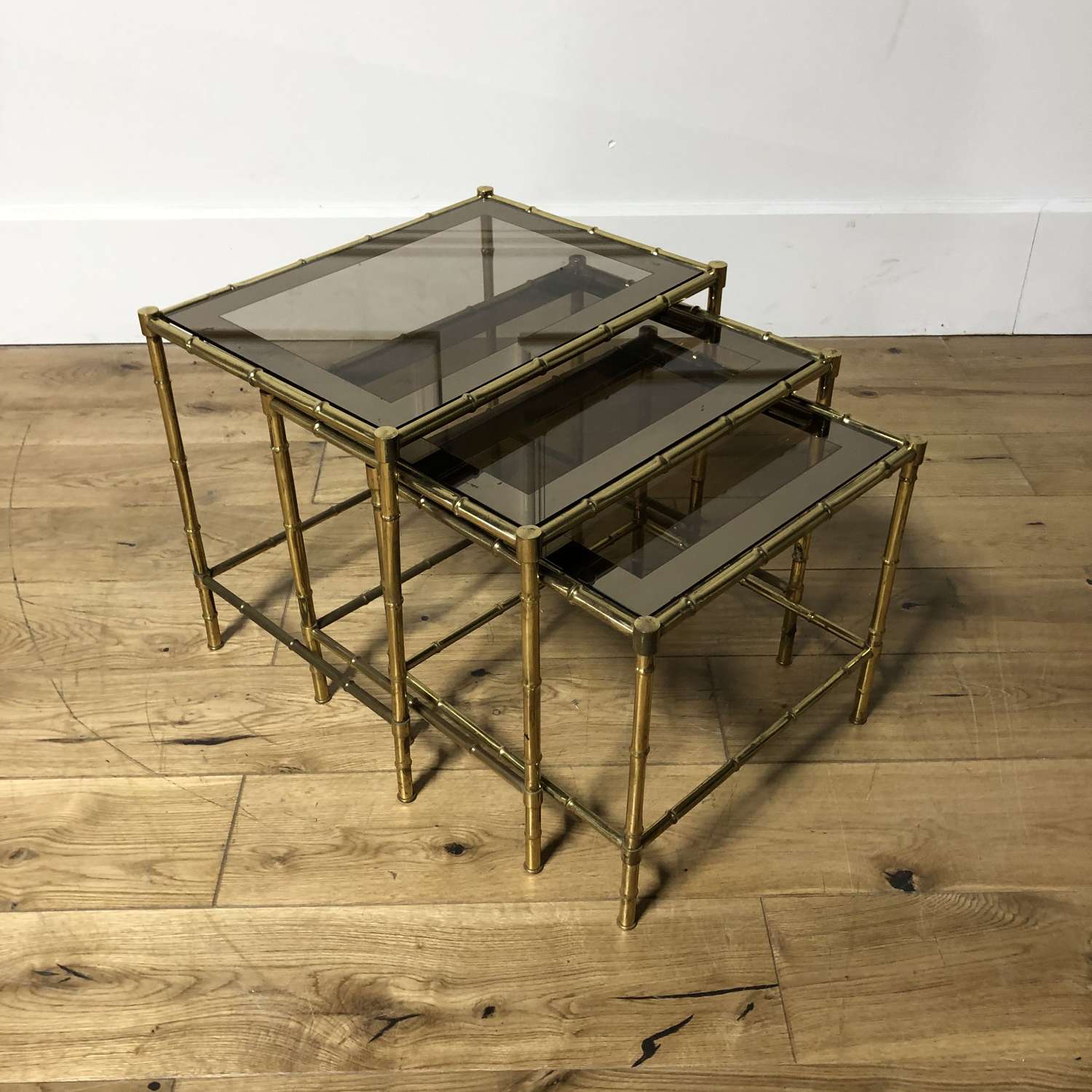 A brass and glass nest of tables