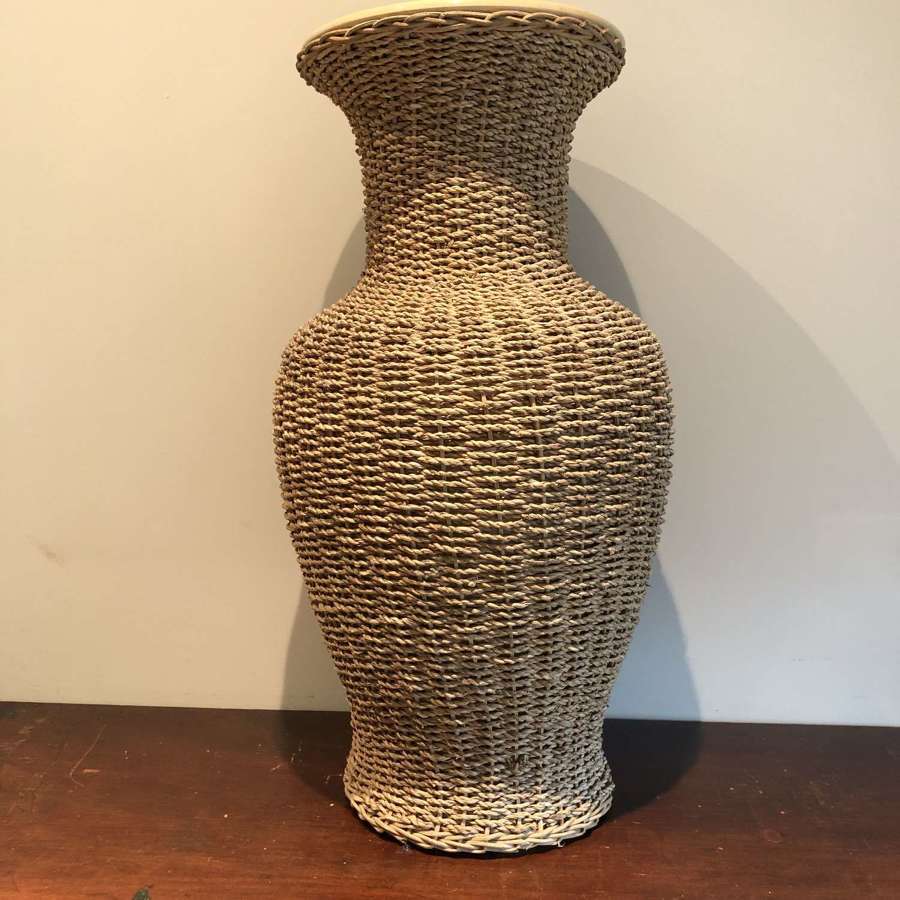 A large rattan clad ceramic vase