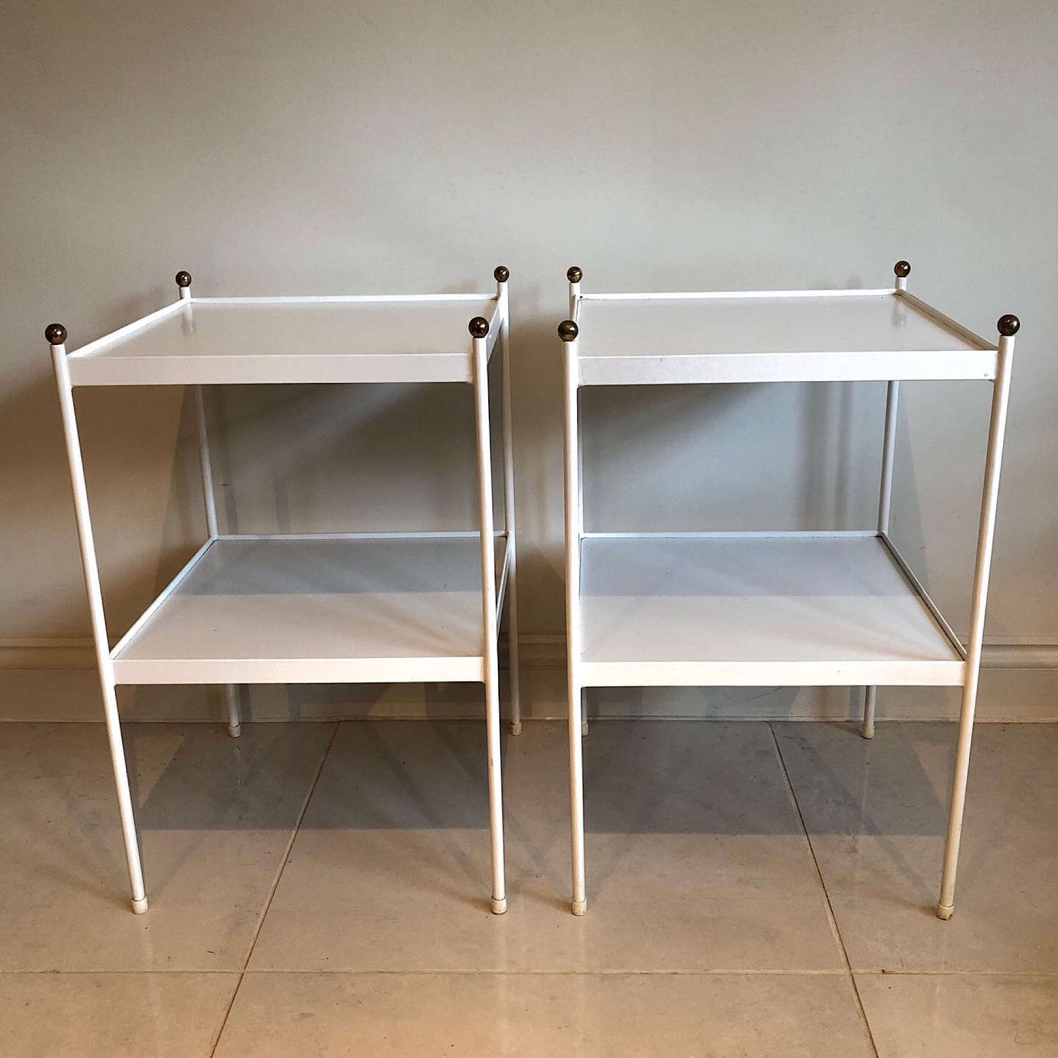 A pair of white two tier tables