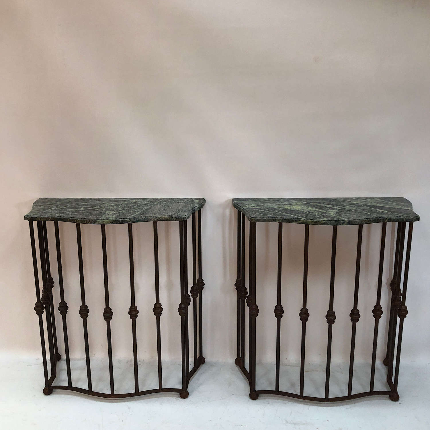A pair of serpentine wrought iron consoles