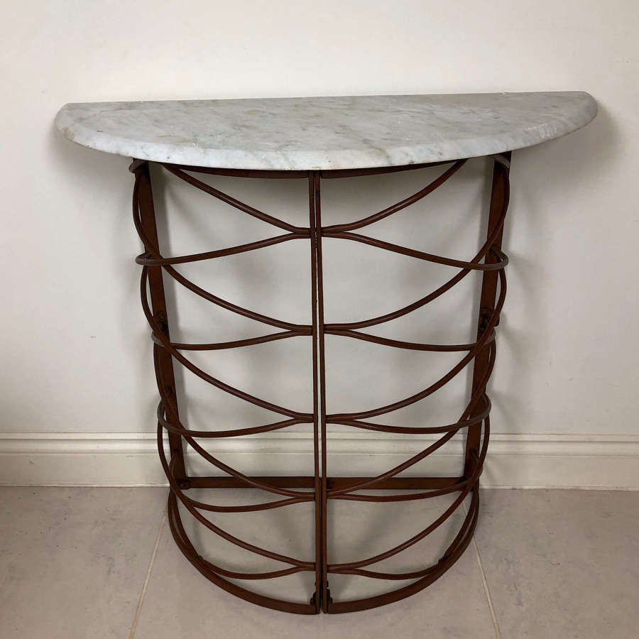 A wrought iron and marble console table